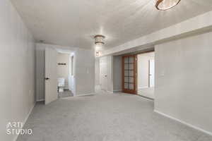 Unfurnished room with a textured ceiling and carpet
