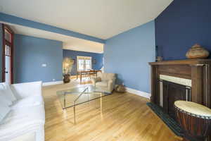 Living area with light wood-style floors and a fireplace with flush hearth