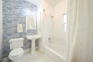 Full bathroom with shower / bathtub combination with curtain and tile patterned floors
