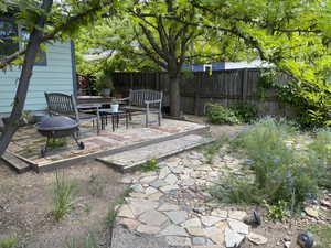 Fenced backyard featuring a patio area and grilling area