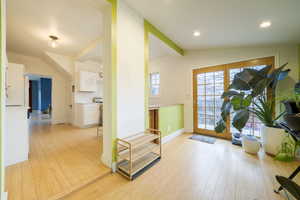 Entryway with vaulted ceiling and light wood finished floors