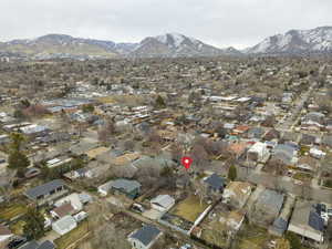 Aerial view of property and surrounding area featuring a mountain backdrop and nearby suburban area