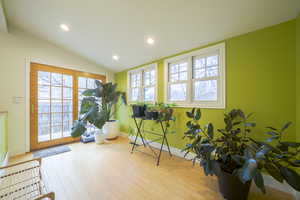 Exercise room with healthy amount of natural light, wood-type flooring, recessed lighting, and vaulted ceiling