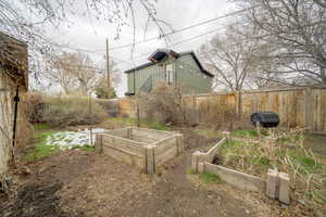 Fenced backyard featuring a vegetable garden