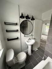 Full bath featuring dark tile patterned floors, dark carpet, a bath, and a textured ceiling