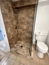 Full bathroom featuring a shower stall and tile patterned flooring