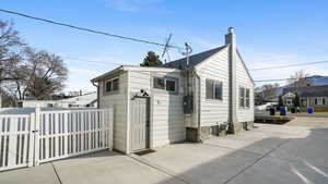 Back of house featuring a chimney and a gate