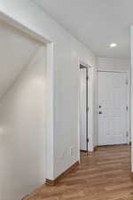 Hallway off the family/tv and dining nook area that leads to downstairs (first left), powder bathroom (second left), garage (third left), and laundry room (follow hall to right).