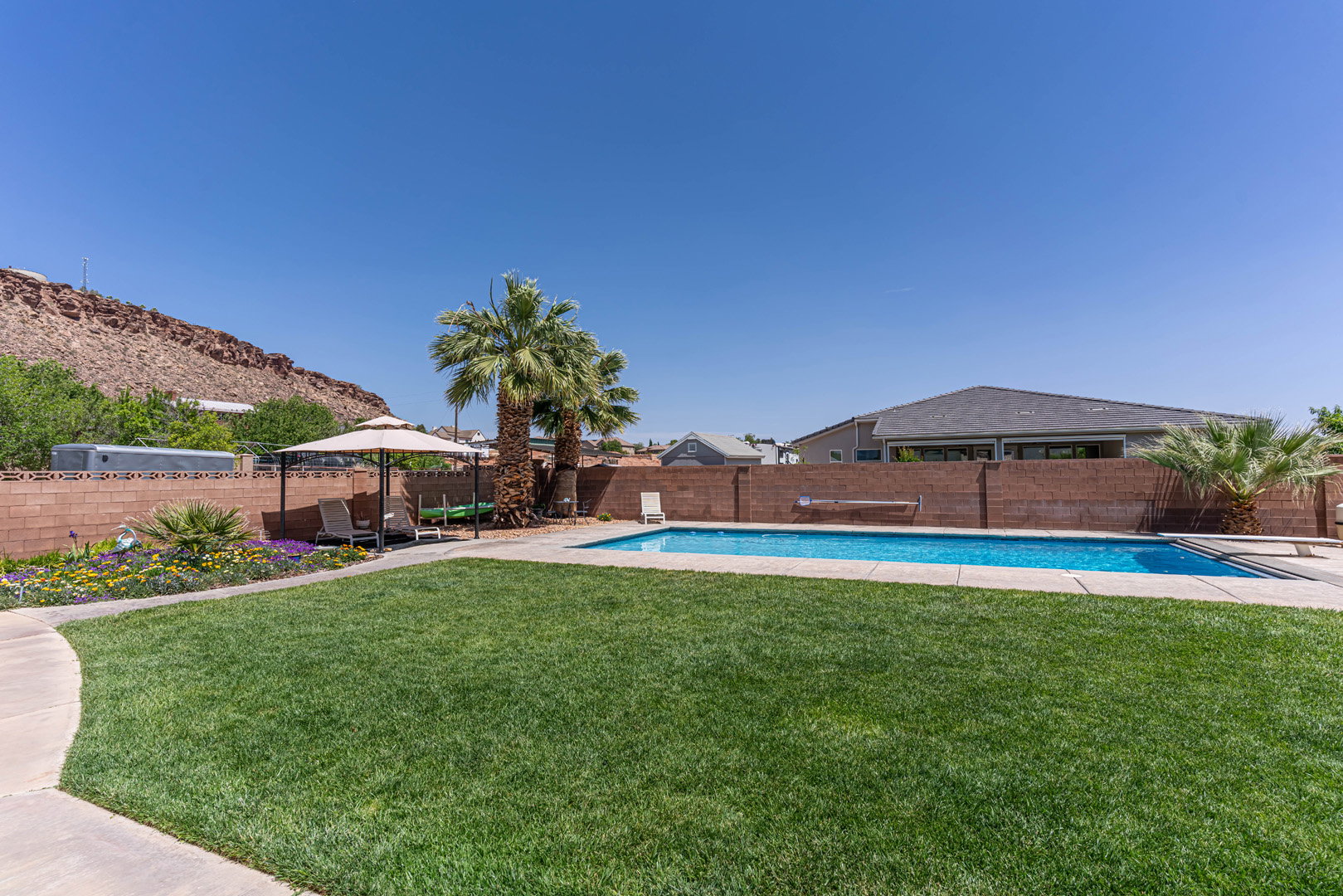 View of swimming pool featuring a fenced backyard, patio surround, and a diving board