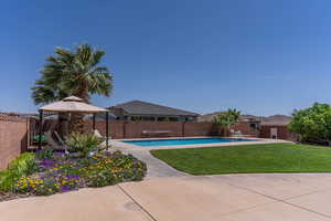 View of swimming pool with a fenced backyard, patio surround, gazebo, and additional parking behind a gate.