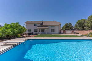 View of pool with patio surround, a diving board, and a fenced backyard