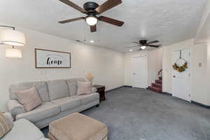 Downstairs living room looking back toward stairs and door (on left) that leads to storage room.