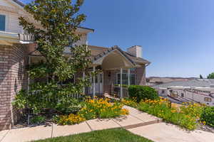 View of front porch with flower garden outlining the walkway.