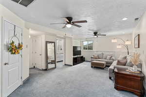 Downstairs living room with additional storage closet (door on left), full bathroom and walk-in storage room (left after door), and large bedroom (back).