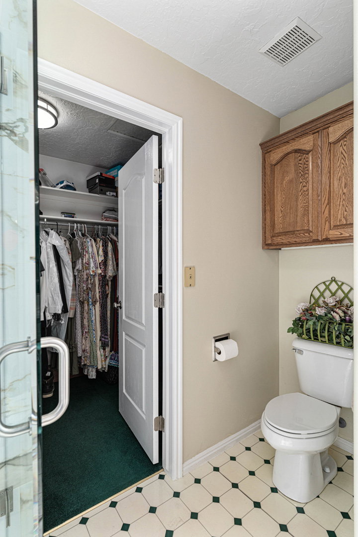 Walk-in primary closet with door to separate from from bathroom.