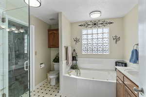 Primary bathroom with separate tub and enclosed glass shower. The closet is located in the back.