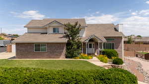 Traditional home with brick siding, a chimney, and a tiled roof