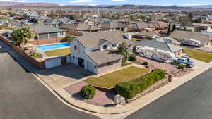 Aerial view of residential area featuring a mountain backdrop and a pool