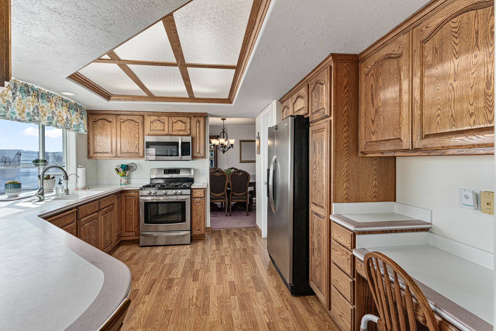 Open kitchen with a window over sink that looks into the backyard. The built in desk area is the perfect spot to do some work while grabbing a bite to eat.
