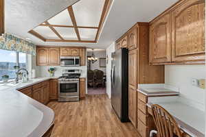 Open kitchen with a window over sink that looks into the backyard. The built in desk area is the perfect spot to do some work while grabbing a bite to eat.