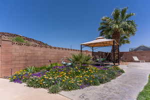 Fenced backyard featuring a gazebo