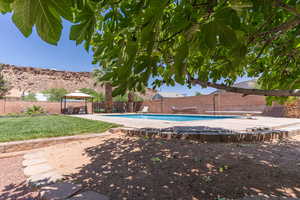 View of swimming pool with a gazebo, a fenced backyard, patio surround, and a diving board