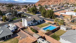 Aerial perspective of neighborhood with a mountainous background and a pool area