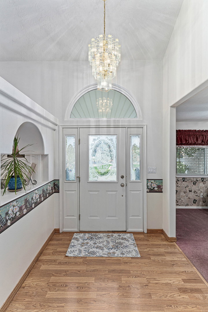Open front entry with office to the right and formal living room to the left.