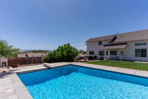 View of swimming pool featuring patio surround, a fenced backyard, and a diving board