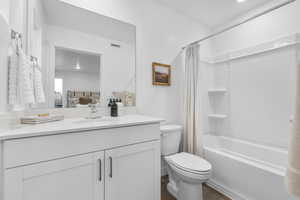 Bathroom with vanity, shower / bath combo, dark wood-type flooring, and connected bathroom