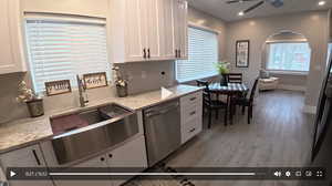 Kitchen with white cabinetry, dishwasher, light stone counters, recessed lighting, and light wood-type flooring