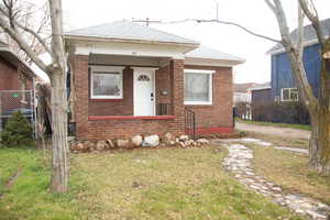 View of front of property featuring brick siding and a shingled roof