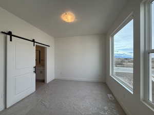 Primary bedroom suite with large windows, featuring barn door to the bedroom.