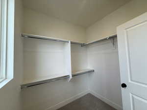 Spacious walk in closet with window in the primary suite.