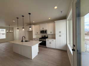 Spacious kitchen with large island, pendant lights, lots of cabinet space and a large pantry.