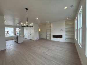 Living and dining space featuring park views out the window, electric fireplace & bookshelves.