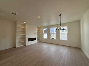 Living and dining space featuring park views out the window, electric fireplace & bookshelves.
