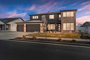 View of front of a 2-story single family home featuring concrete driveway, a 3-car garage, and brick siding