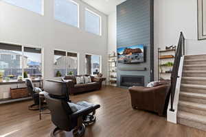 Living area featuring a newly shiplapped fireplace, wood finished floors, and a 20ft high vaulted ceiling