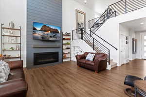 Living area featuring a 20 ft. high lofted ceiling, wood finished floors, a large newly shiplapped fireplace, and recessed lighting