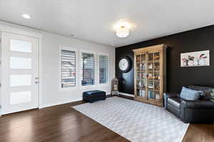 Entryway area with dark wood finished floors and plantation shutters