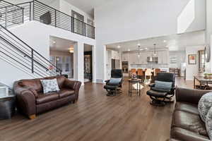 Living area with dark wood-type flooring, recessed lighting, and a high ceiling