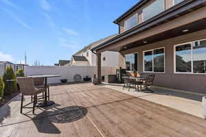 Fenced, fully lanscaped backyard with a stamped and dyed concrete patio and outdoor dining area