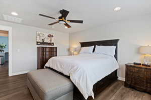 Primary bedroom featuring dark wood-style flooring, ceiling fan, recessed lighting, and a textured ceiling
