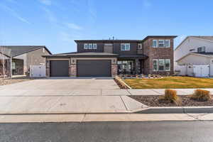 View of front of a 2-story single family home featuring concrete driveway, a 3-car garage, and brick siding