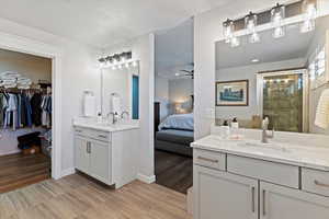 Full en-suite bath servicing primary bedroom, two separate vanities and walk-in closet