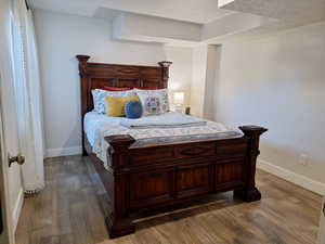 Bedroom with wood finished floors and baseboards