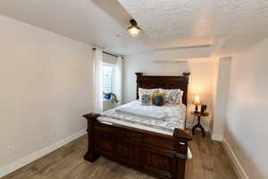 Bedroom with dark wood-style floors and a textured ceiling