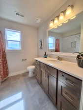 Bathroom with vanity, a shower with shower curtain, and light tile patterned floors