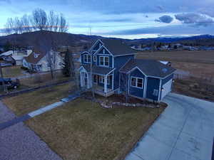 View of front of home with driveway, a front yard, a mountain view, and an attached garage